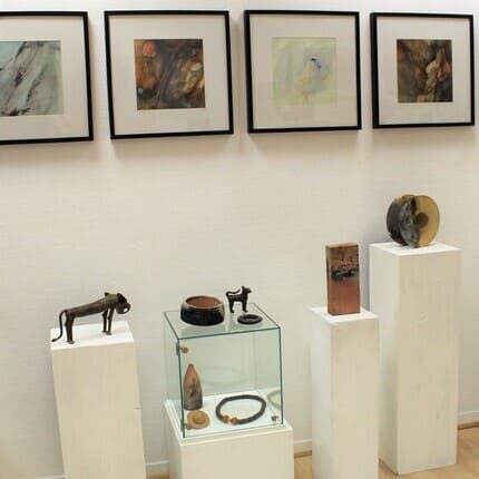 Galeriesäulen mit Bronzeobjekten und Keramik, an der Wand 4 Bilder