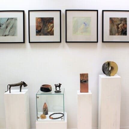 Galeriesäulen mit Bronzeobjekten und Keramik, an der Wand 4 Bilder